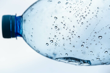 Detail of a blue plastic bottle neck with water drops inside, macro shot, selective focus.