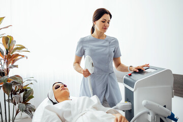 Portrait of relaxed young female client getting SMAS ultrasound face lifting massage