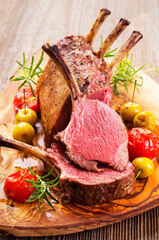 Traditional barbecue carree of venison with fruitsand tomatoes served as close-up on a classic...