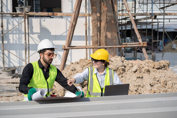 Caucasian engineer man and woman working with paper work at construction site	