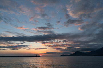 lighthouse at sunset and magnificent sky with textured clouds