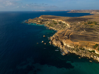 Scenic golden rocky cliffs in Malta. Aerial photo near famous Golden Bay Beach.