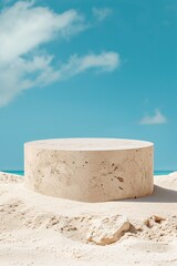 Fototapeta na wymiar A beige stone textured podium in round-shaped displayed on the sand. Blue sky background