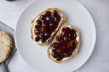 Whole grain bread with strawberry jam on top. Composition with delicious homemade jam on a plate....