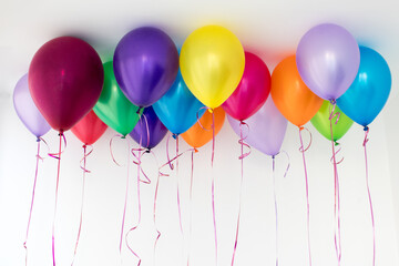 Many balloons on a white background with threads hang in space under the stream. Bright different...