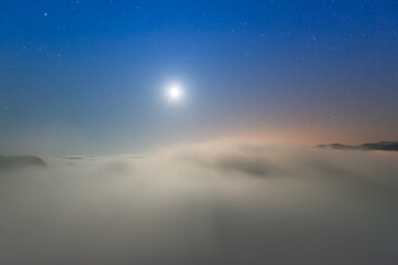 Obraz premium The sea of clouds on a quiet moonlit night makes you feel unpredictable. Peaks surrounding Emerald Reservoir. Xindian District, New Taipei City, Taiwan.