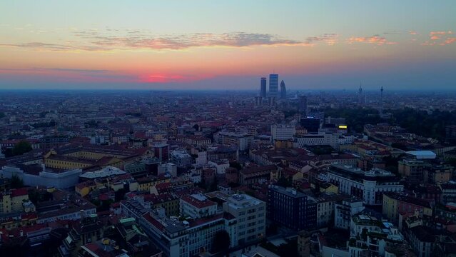 Aerial view of Milan city skyline at sunrise flies backwards. Theatrical performance is filmed from the Milan cityscape at sunset. Aerial photography. skyscrapers on the mountain zone of Milan. Italy