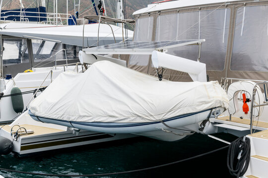 Inflatable tender motor boat on swim platform of superyacht. Inflatable dinghy with outboard engine. Power boat.