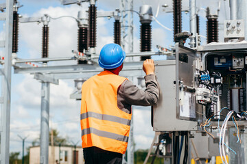 Adult electrical engineer inspect the electrical systems at the equipment control cabinet....