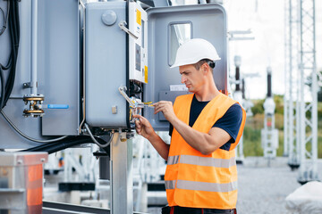 Adult electrical engineer inspect the electrical systems at the equipment control cabinet....