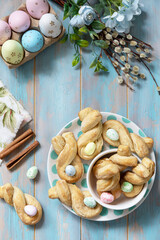 Easter rabbit-shaped buns puff pastry with  cinnamon on a wooden blue tabletop. View from above. Copy space.