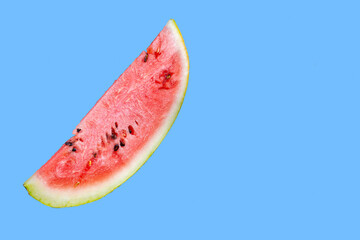 A piece of juicy watermelon on a blue background. Watermelon slice isolated on blue background....
