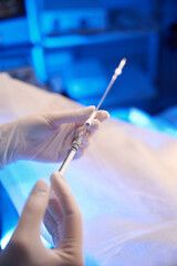 Selective focus of doctor hands using syringe for embryo transfer