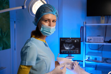 Fototapeta na wymiar Female doctor using syringe for embryo transfer in reproductive clinic