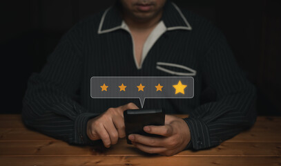 A business professional uses a mobile device to give a 5-star rating, expressing satisfaction and...