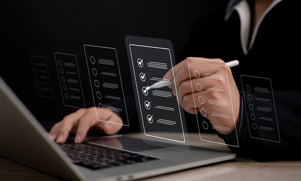 A businessman uses a stylus pen on his laptop to complete performance checklists for online assessments, surveys, and exams, providing a digital and efficient approach to evaluation