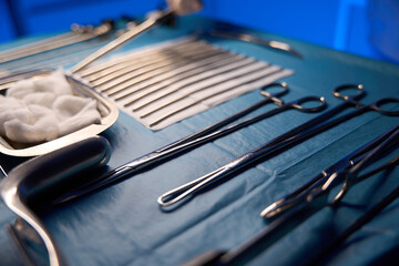 Focus of scalpel on foreground of doctor hand preparing medical equipment