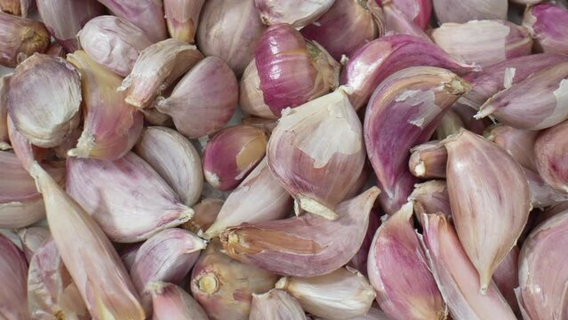 Capture the intricate beauty of garlic bulbs up close with stunning macro shots. Witness the textures and colors of garlic in exquisite detail. Food stock footage.
