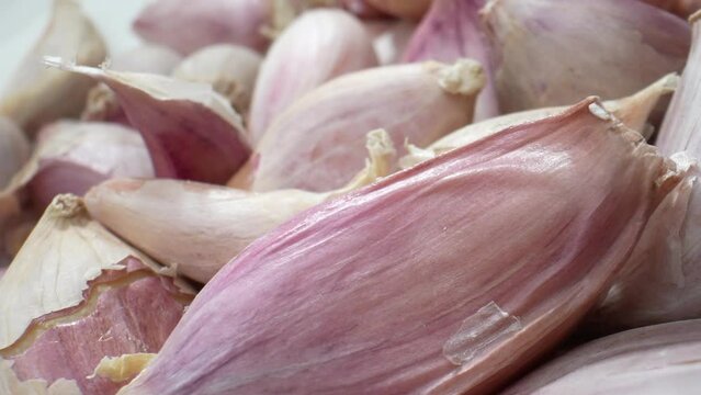 The intricate beauty of garlic cloves in mesmerizing macro detail. Each bulging segment and delicate papery skin is a testament to nature's artistry. Fruit and vegetable concept. Food stock footage.
