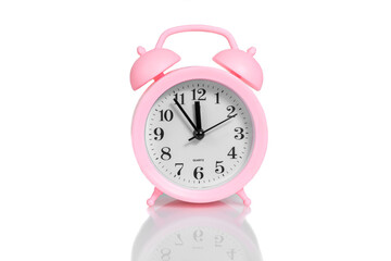 pink alarm clock set twelve o'clock isolated over white background