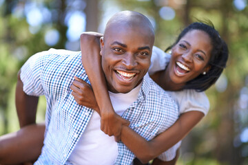 Piggyback, portrait or happy black couple in forest to relax or bond on holiday vacation together...
