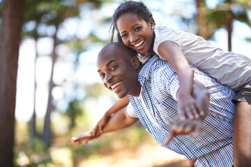 Piggyback, portrait or black couple playing in park to relax or bond on holiday vacation together...