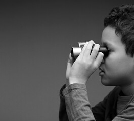 boy looking through binoculars on gray background stock photo	