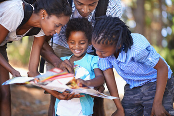 Travel, map and children with parents in a forest for location, direction or search outdoor...