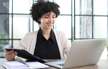 Portrait of Young Successful Caucasian Businesswoman Sitting at Desk Working on Laptop
