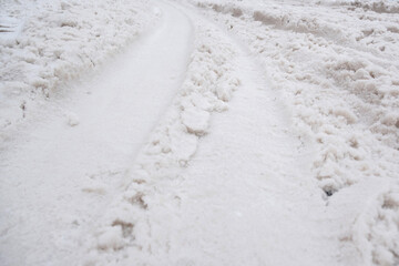 Tracks from a passing car, on the snow. A car drove through the white snow