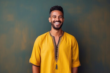 happy Moroccan man with typical moroccan tunic standing against wall - obrazy, fototapety, plakaty