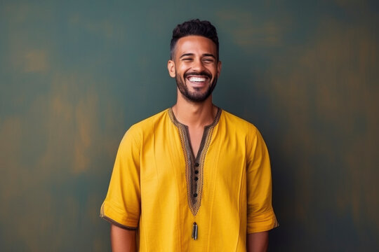 happy Moroccan man with typical moroccan tunic standing against wall