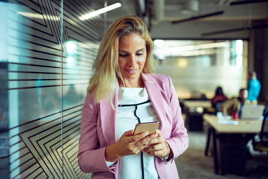 Young businesswoman using smartphone in modern office