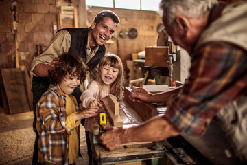 Happy family woodworking together in a workshop