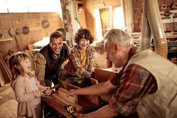 Happy family woodworking together in a workshop