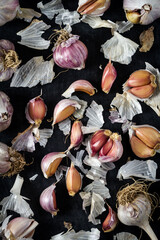 Fresh garlic bulbs and cloves grouped on black background