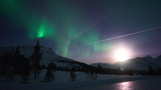 Moonrise and aurora in a mountainous snowy landscape on January 1st 2024.