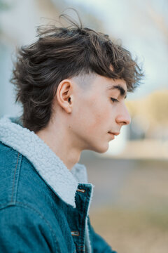 De perfil chico apuesto luciendo corte de cabello