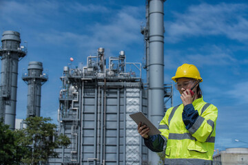 worker with helmet. Worker  woman hand hold tablet working  with power plant on background. Portrait engineer working on power plant.