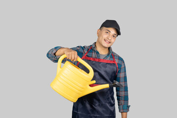 Young Asian Muscular Gardener wearing apron  with plants and watering tools gives gestures