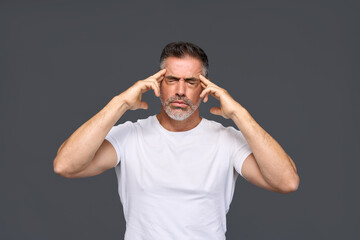 Fototapeta na wymiar Unhappy stressed older man, annoyed sad middle aged male model wearing white t-shirt feeling pain having severe headache or migraine touching head standing isolated on gray background.