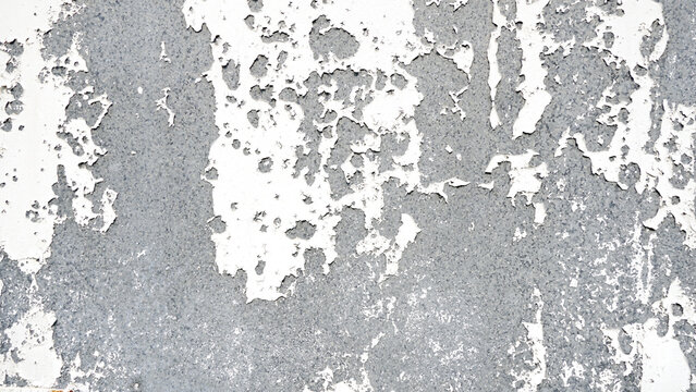 White paint peeling off concrete wall, old white painted background.
