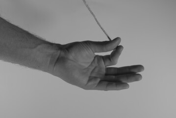 hand of a person holding piece of string. Concept art performance