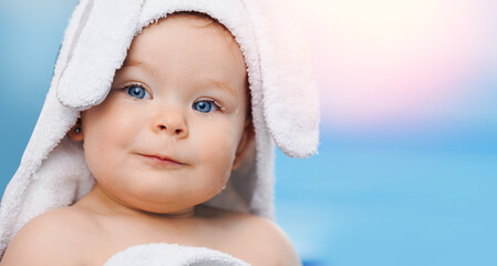 Portrait Cute happy laughing baby girl in white towel with ears after swimming lessons in pool,...