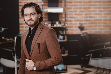 Concept status men client in barbershop. Portrait stylish man in jacket and glasses against...