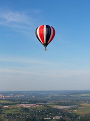 Colorful hot air balloon against the blue sky. Balloon flight. Summer morning.