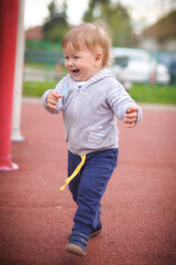 Lively, happy and smiling boy happily runs around the children's playground, exploring the wonders of the natural world. Child, happiness and people concept
