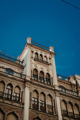 Fototapeta na wymiar Seville's Architectural Tapestry: Vintage and Moroccan Fusion Against Azure Sky