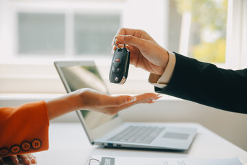 Closeup asian male people car salesman or sales manager offers to sell a car and explains and reads the terms of signing a car contract and insurance.