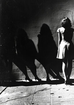 Dramatic shadows of women on a sidewalk in black and white photography